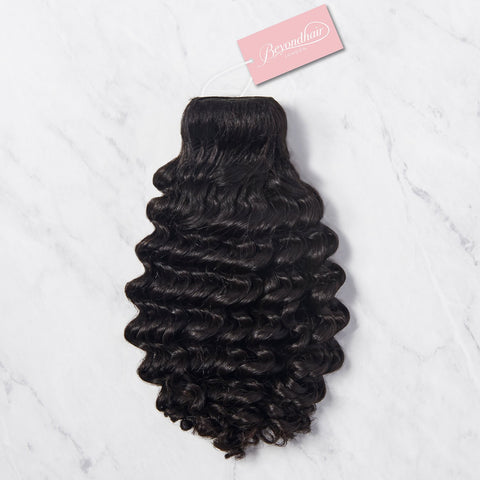 curly peruvian hair bundle resting on marble table